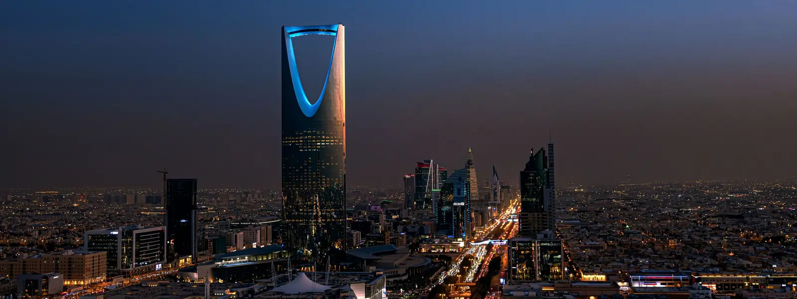 Aerial night view of Riyadh with Kingdom Centre tower and King Fahd Road traffic light trails